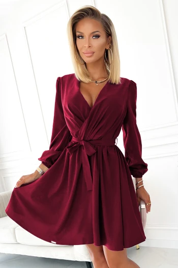 The woman in the photo is wearing a stylish green midi dress, highlighting its elegant silhouette. The model showcases the dress's sophisticated design, perfect for any occasion.