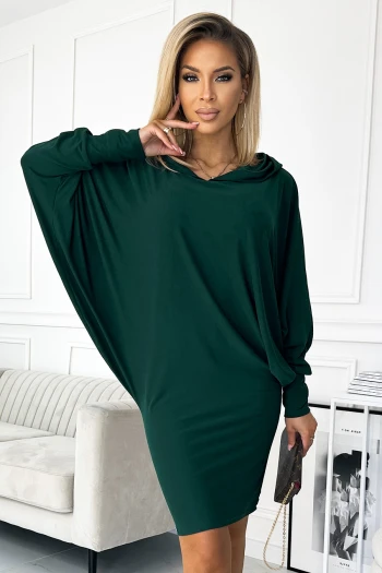 The woman in the photo is wearing a stunning green evening gown, featuring a deep V-neck and elegant flutter sleeves. This glamorous dress is perfect for formal occasions, highlighting the timeless appeal of a classic evening gown.