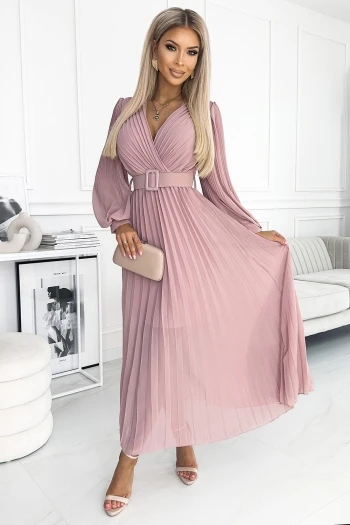 The woman in the photo is wearing a stunning green pleated dress with a belted waist, highlighting the elegant design. This chic green dress is perfect for any sophisticated occasion, adding a touch of class to your wardrobe.