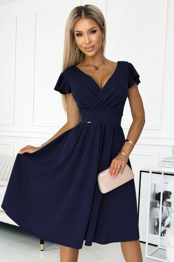 The woman in the photo is wearing a stylish beige ruffle dress, featuring intricate lace detailing along the neckline. This elegant ruffle dress is perfect for adding a touch of sophistication to any wardrobe.