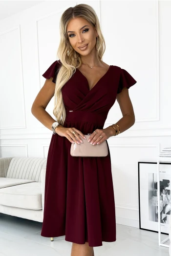 The woman in the photo is wearing a stunning burgundy evening gown, featuring a flattering sweetheart neckline and elegant slit. This glamorous dress is perfect for formal occasions, showcasing the beauty and sophistication of the evening gown.