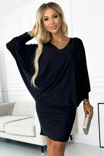 The woman in the photo is wearing a stylish navy dress with elegant ruffle sleeves, perfect for any formal occasion. She holds a chic nude clutch, complementing the sophisticated look of the navy dress ensemble.