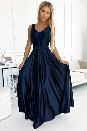 The woman in the photo is wearing a stunning royal blue pleated maxi dress, featuring a flattering V-neckline and elegant long sleeves. This pleated maxi dress is accentuated with a matching belt, creating a sophisticated and stylish look.