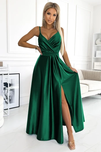 The woman in the photo is wearing a stunning navy blue backless gown, elegantly showcasing its flowing silhouette. This elegant dress features a crisscross strap design, perfect for making a statement at any formal event.