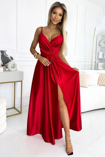 The woman in the photo is wearing a stunning red tulle dress, elegantly designed with a deep V-neckline and a sparkling belt accent. This red dress showcases a perfect blend of sophistication and style, ideal for any special occasion.