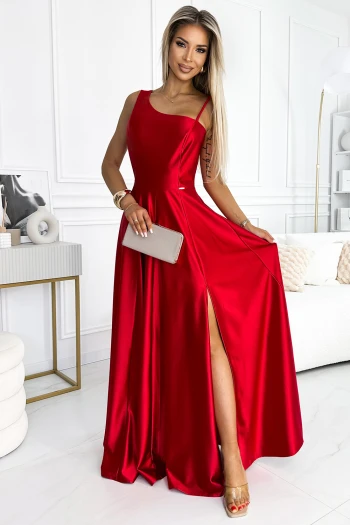 The woman in the photo is wearing a stunning pink tulle dress with a deep V-neckline, elegantly accentuated by a sparkling circular brooch at the waist. This pink tulle gown exudes sophistication and charm, perfect for any formal occasion.