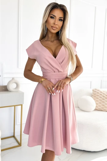The woman in the photo is wearing a chic beige wrap dress that elegantly drapes to highlight its flowing design. This stylish wrap dress is perfect for both casual outings and formal occasions, offering a versatile addition to any wardrobe.