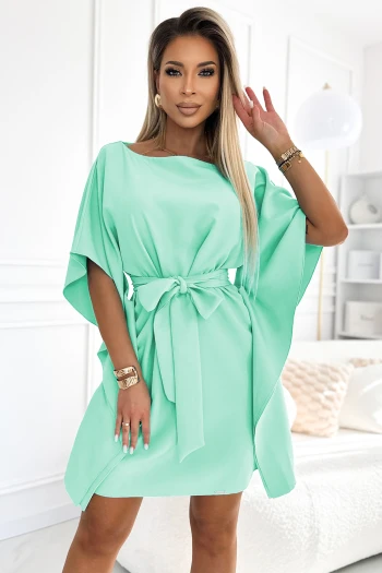 The woman in the photo is wearing a stylish brown kimono dress, featuring a flattering waist tie that enhances its elegant silhouette. This kimono dress offers a chic and versatile look, perfect for both casual and formal occasions.