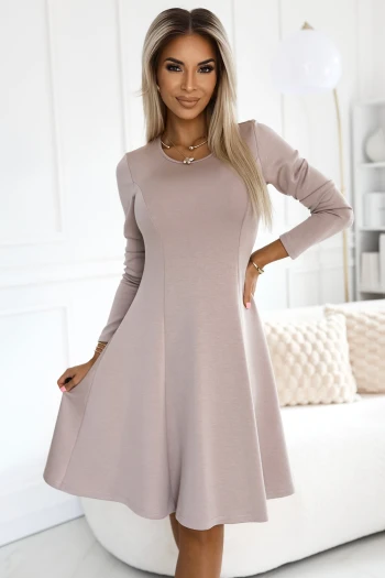 The woman in the photo is wearing an elegant green dress with a flattering square neckline and long sleeves. The model showcases the dress's flowing silhouette, perfect for both casual and formal occasions.
