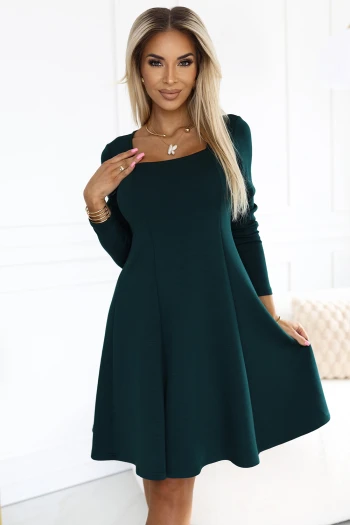 The model showcases a chic green dress with a flattering silhouette, perfect for both casual and formal occasions. This elegant green outfit is complemented by her stylish accessories, highlighting its versatile design.