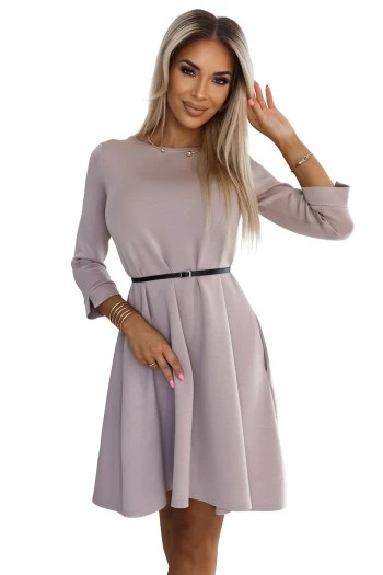 The woman in the photo is wearing a chic white blouse with a bow detail, paired with a stylish tan skirt. This elegant outfit perfectly highlights the blouse's delicate pattern and the skirt's sophisticated design.
