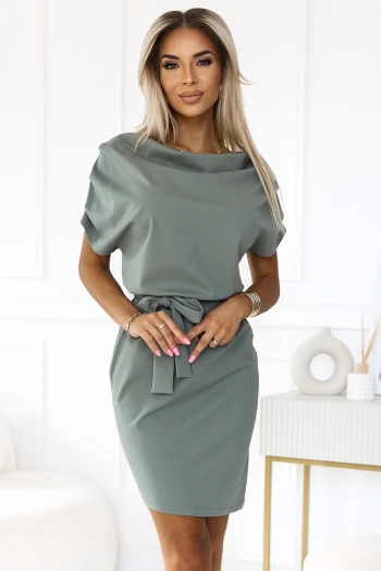 The woman in the photo is wearing a chic beige blouse with a stylish bow tie, perfectly paired with a sleek black leather skirt. This elegant combination highlights the versatility of the blouse and skirt set for any occasion.