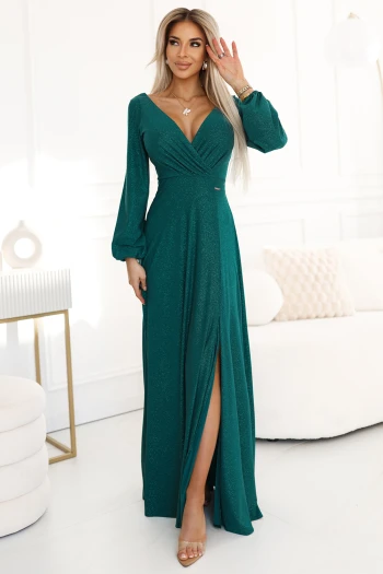 The model showcases a stunning navy blue glitter dress, highlighting its elegant wrap design. This shimmering blue dress is perfect for evening events, offering a sophisticated and stylish look.