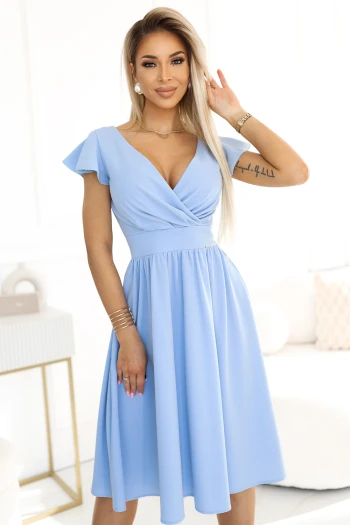 The woman in the photo is wearing a stylish blue midi dress with a ruched design and side slit, perfect for elegant occasions. This chic blue dress highlights a sophisticated look, ideal for making a fashion statement.
