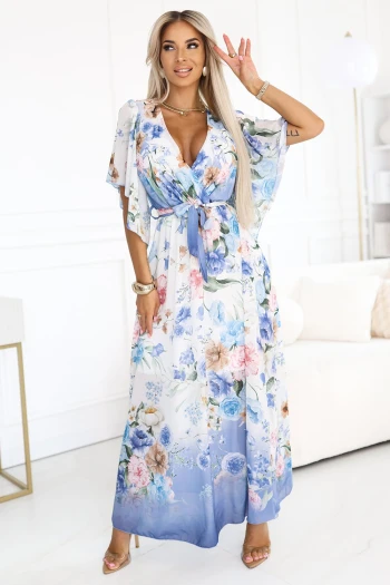 Modelka prezentuje elegancką sukienkę maxi w kwiaty, która idealnie podkreśla kobiecą sylwetkę. Sukienka maxi w kwiaty z delikatnym paskiem w talii dodaje stylizacji lekkości i romantyzmu.