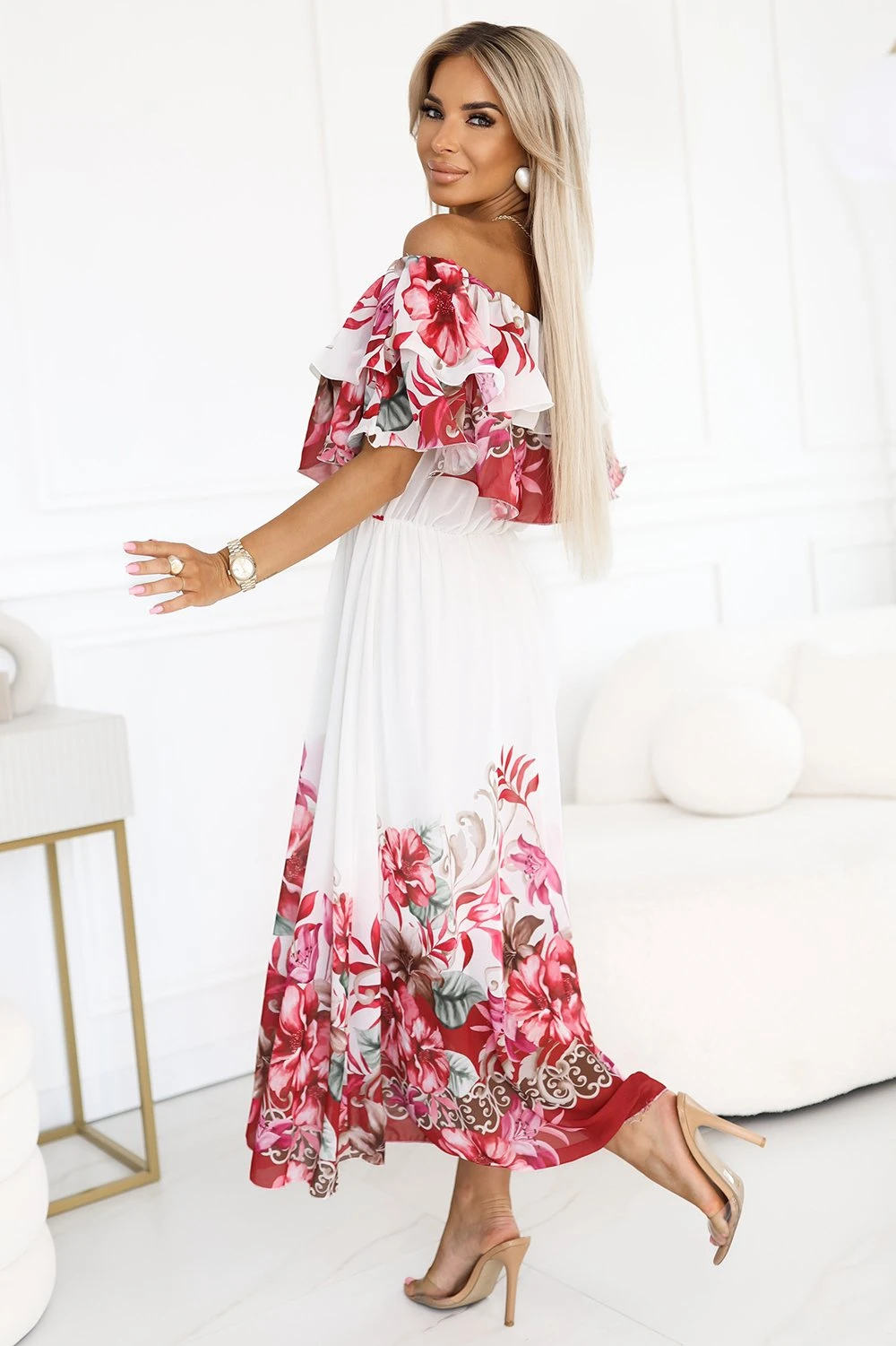 The woman in the photo is wearing a stunning floral maxi dress, featuring a vibrant pattern and a stylish belt. This elegant maxi dress perfectly combines comfort and fashion for any occasion.