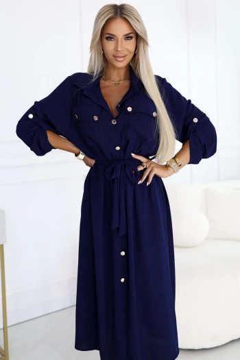 The woman in the photo is wearing a stunning blue pleated maxi dress, exuding elegance and style. The dress features delicate ruffle details, making it a perfect choice for any special occasion.