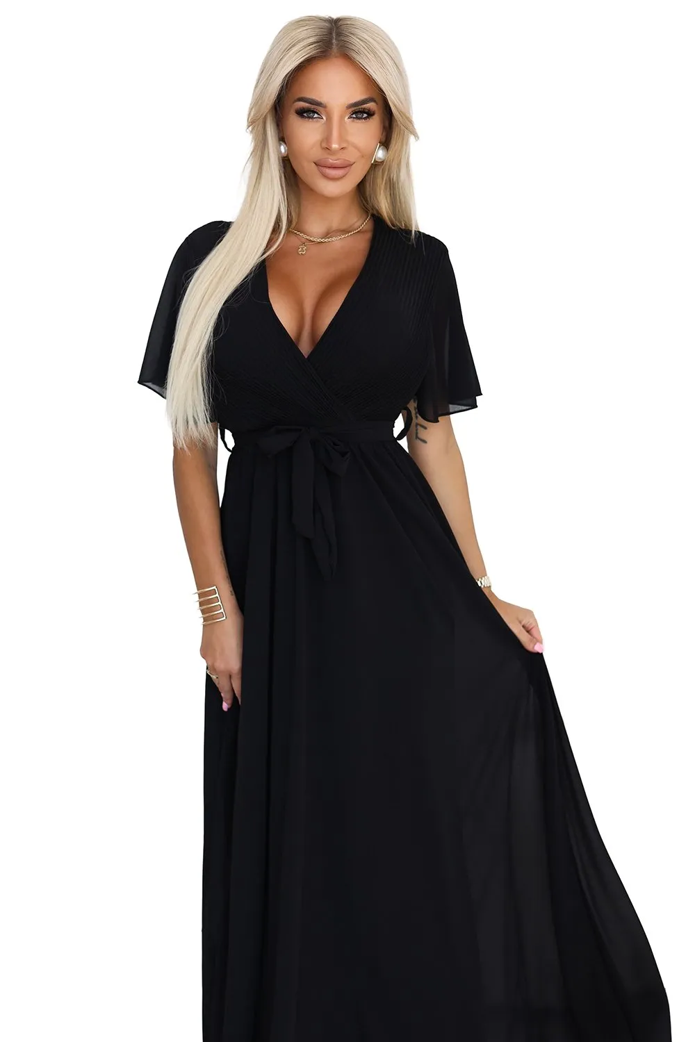 The woman in the photo is wearing a stunning brown evening gown, elegantly adorned with black lace detailing. The model showcases the gown's sleek silhouette, perfect for formal occasions.