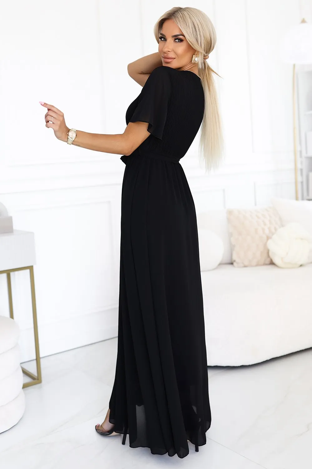 The woman in the photo is wearing a vibrant red lace dress, showcasing intricate floral embroidery. This elegant lace dress highlights a sophisticated neckline, perfect for special occasions.