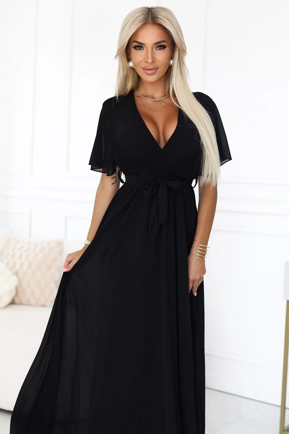 The woman in the photo is wearing a stunning red lace skater dress, featuring intricate detailing on the bodice. This elegant skater dress is perfect for making a bold fashion statement at any event.