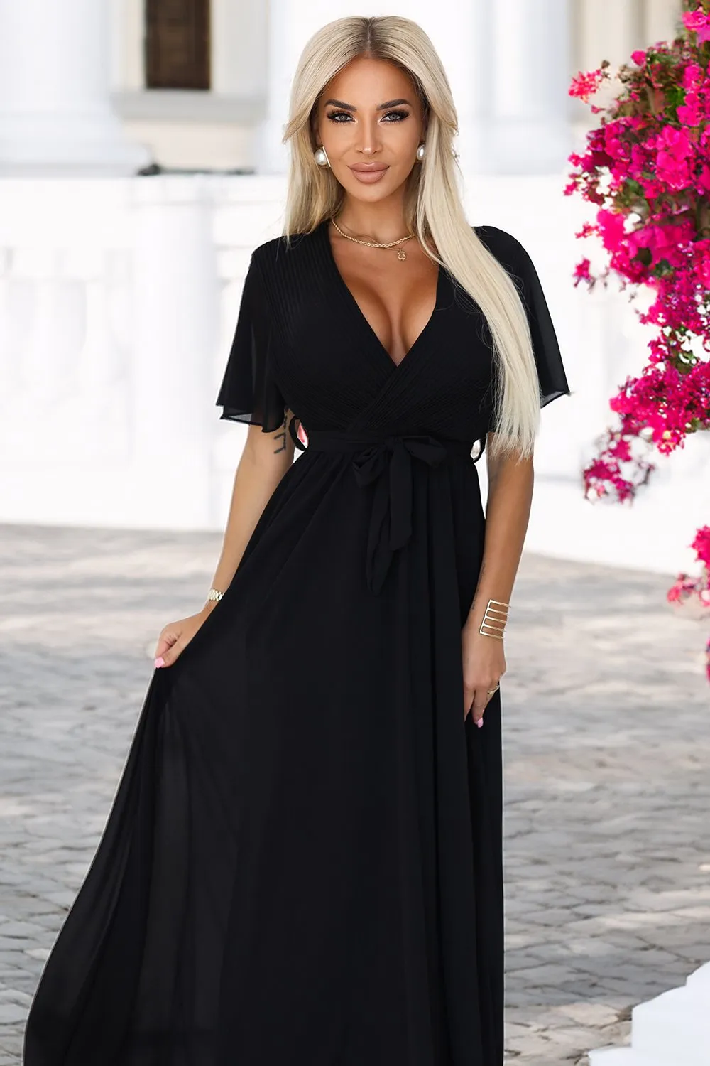 The woman in the photo is wearing a stunning brown maxi dress with elegant black lace detailing. This chic maxi dress perfectly complements her sophisticated style, making it ideal for formal occasions.