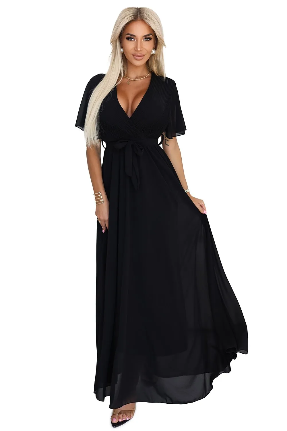 The woman in the photo is wearing a stunning brown evening gown with intricate black lace detailing. This elegant dress perfectly highlights the sophisticated design, making it ideal for formal occasions.