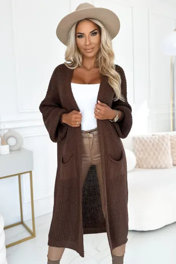 The woman in the photo is wearing a chic green dress with elegant long sleeves, perfect for any occasion. This stylish green dress highlights a sophisticated design that complements her look beautifully.